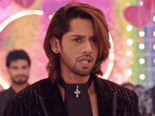 a man with long hair and a beard wearing a choker with a cross on it .
