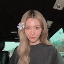 a woman with a flower in her hair is smiling for the camera
