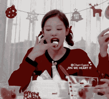 a girl is eating a piece of cake with a merry xmas banner in the background