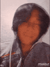 a close up of a person wearing a hoodie and earbuds