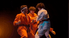 a man in orange pants is doing a kick