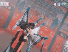 a man in a black outfit is dancing in front of a chinese sign