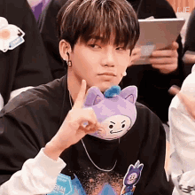 a young man holds a stuffed animal with a cat on it in front of his face
