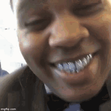 a close up of a man wearing a bow tie and a suit with a lot of teeth .
