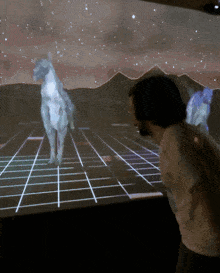 a man stands in front of a screen that shows a horse on it