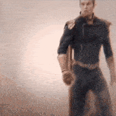 a blurry picture of a man in a superhero costume standing in front of a white wall .