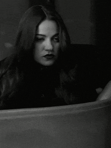 a black and white photo of a woman with long hair and red lips