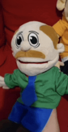 a person is holding a puppet with a mustache and a green shirt .