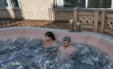 a man and a woman are in a hot tub with candles in the background