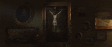 a painting of jesus on the cross hangs on a wall surrounded by other paintings