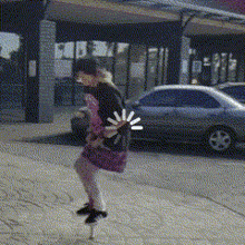 a woman in a pink dress is walking down the street