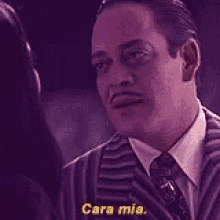 a man in a suit and tie is talking to a woman in a purple background .