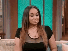 a woman is sitting on a couch with her eyes closed and her mouth open .