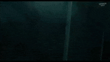 a close up of a monster in a dark room with smoke coming out of it 's mouth .