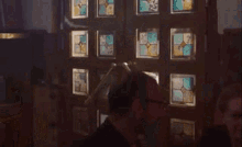 a woman is opening a door to a man in a dark room .