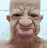 a bald man wearing a mask with his tongue out