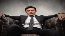 a man in a suit and tie is sitting in a chair with the number 457 written on the bottom