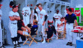 a group of baseball players are in a locker room and one of them has the number 24 on their jersey