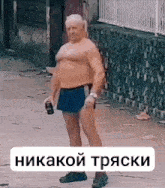 a shirtless man in blue shorts is holding a bottle of alcohol .