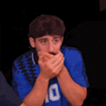 a man in a blue shirt with the number 10 on it is clapping his hands