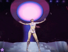a woman in a crop top and short skirt is dancing on a stage