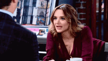 a woman in a purple dress is sitting at a table with a man .