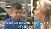 a little boy is sitting next to a woman in a garage and talking to her .