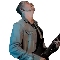 a man in a denim shirt playing an electric guitar