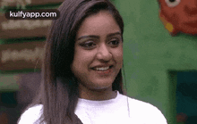 a woman is smiling and looking at the camera .