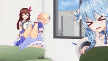 a girl with blue hair is sitting on a couch next to another girl