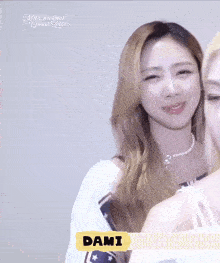 two women are standing next to each other and the word dami is on the bottom right