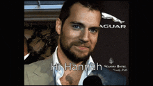 a man with a beard says hi hannah in front of an jaguar logo