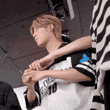 a person wearing a number 10 jersey holds another person 's arm