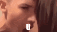 a close up of a person 's face with the letter u in front of them
