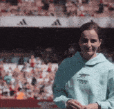a woman wearing a blue emirates fly better sweatshirt