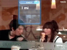 a woman eating an ice cream cone in front of a screen that says knot i mi