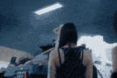 a woman is standing in front of a tank in a room .