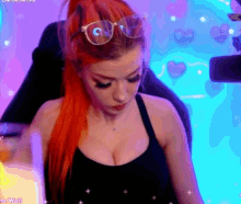 a woman with red hair is wearing sunglasses and a black tank top
