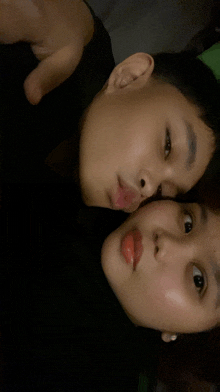 a boy and a girl are posing for a picture and the girl has red lips