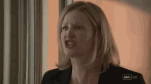 a woman is making a funny face while standing in front of a window in a room .