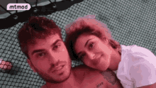 a man and a woman are posing for a picture .