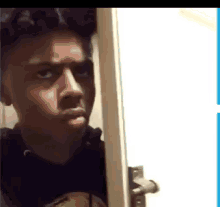 a young man is standing in a doorway making a funny face .