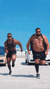 two men are running in a parking lot and one of them is wearing a weight vest
