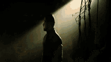 a man in a suit stands in a dark room