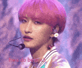 a person with pink hair is wearing a microphone and earrings