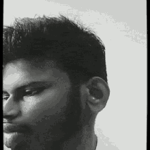 a black and white photo of a man 's face with a beard .