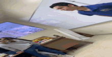 a man in a blue shirt is standing upside down in a room with other people