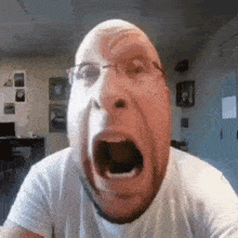 a man with glasses is making a funny face with his mouth wide open .