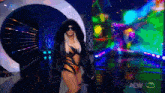 a woman in a fur coat is walking on a stage with a aew hds logo on the bottom