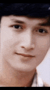 a close up of a young man 's face with a blurred background .